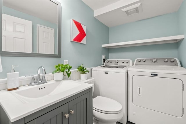 15 University Rd, Arlington, MA 02474 - bathroom featuring washing machine and clothes dryer, toilet, and vanity