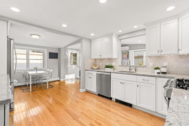 15 University Rd, Arlington, MA 02474 - kitchen featuring stainless steel appliances, a sink, white cabinets, decorative backsplash, and recessed lighting
