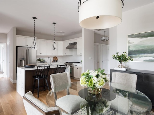 dining area featuring sink and light hardwood / wood-style flooring