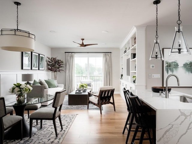 interior space with ceiling fan, sink, and light wood-type flooring