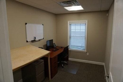 office with a paneled ceiling, visible vents, and baseboards