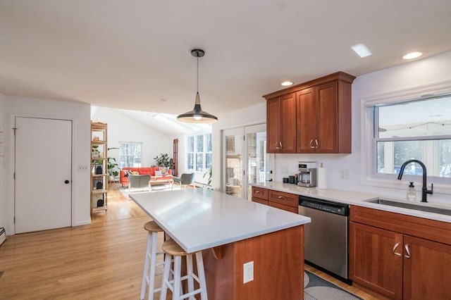 kitchen with a healthy amount of sunlight, light countertops, dishwasher, and a sink