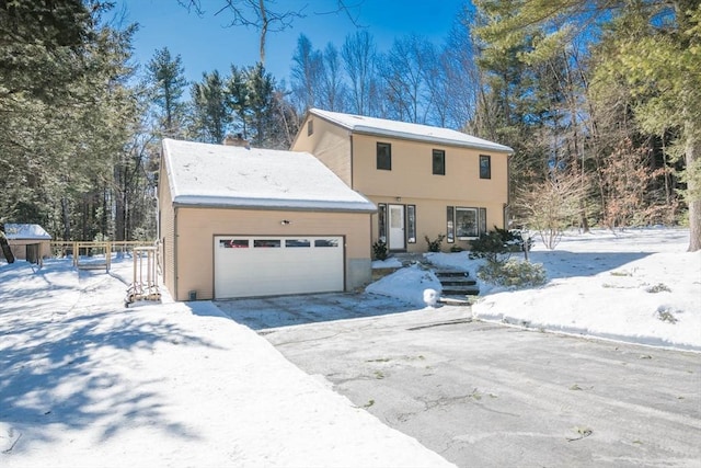 view of front of property featuring aphalt driveway, a chimney, and an attached garage