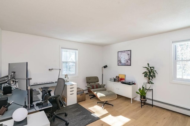 office with a baseboard heating unit, light wood finished floors, and a healthy amount of sunlight