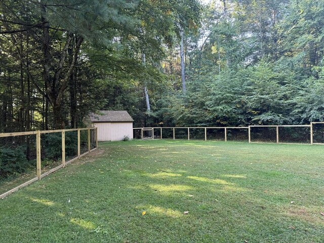 view of yard with an outbuilding, a storage unit, and a fenced backyard