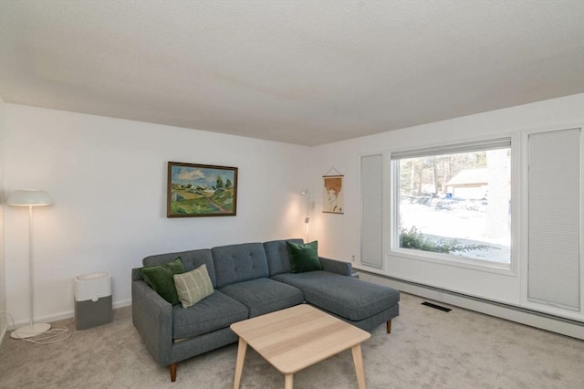 living area featuring a baseboard heating unit, light carpet, and baseboards