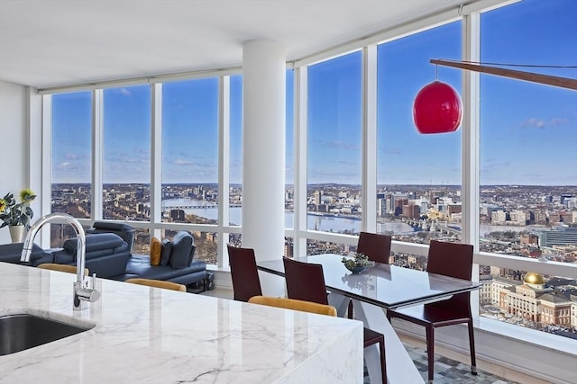 dining space featuring a wall of windows, a city view, and a water view