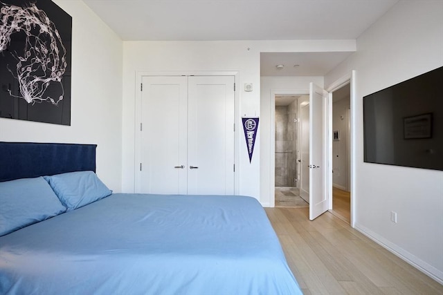 unfurnished bedroom featuring light wood-style floors, a closet, and baseboards