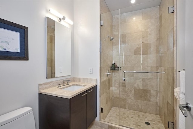 bathroom with a stall shower, vanity, and toilet