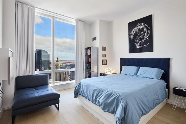 bedroom featuring wood finished floors, visible vents, and baseboards