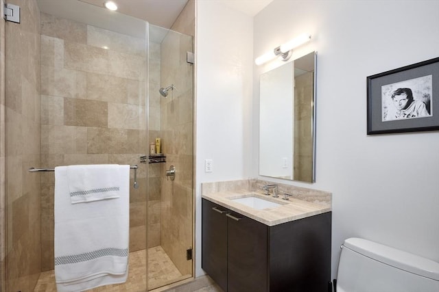 bathroom with a stall shower, vanity, and toilet