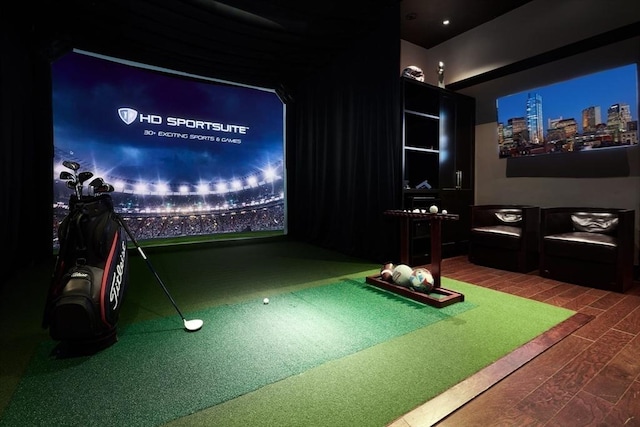 cinema room featuring golf simulator and wood finished floors