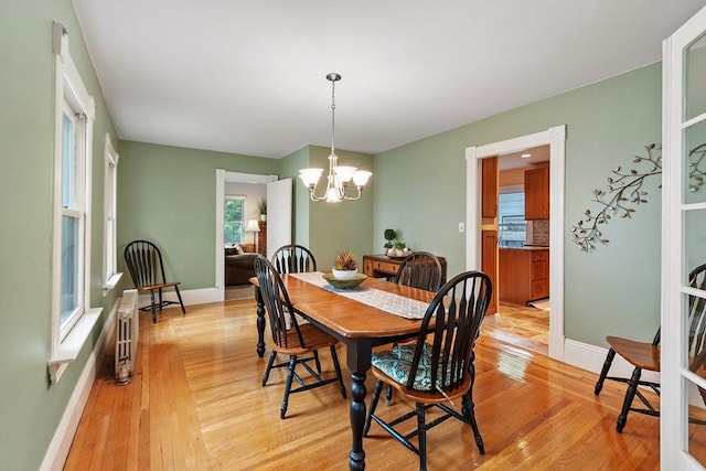 20 Walden St, Lowell, MA 01851 - dining room with a chandelier, light wood finished floors, baseboards, and radiator heating unit