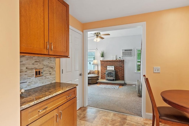 20 Walden St, Lowell, MA 01851 - kitchen with a ceiling fan, dark stone counters, a wall mounted air conditioner, and a brick fireplace