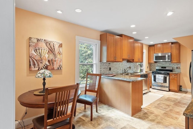 20 Walden St, Lowell, MA 01851 - kitchen with stainless steel appliances, backsplash, a sink, light stone countertops, and recessed lighting
