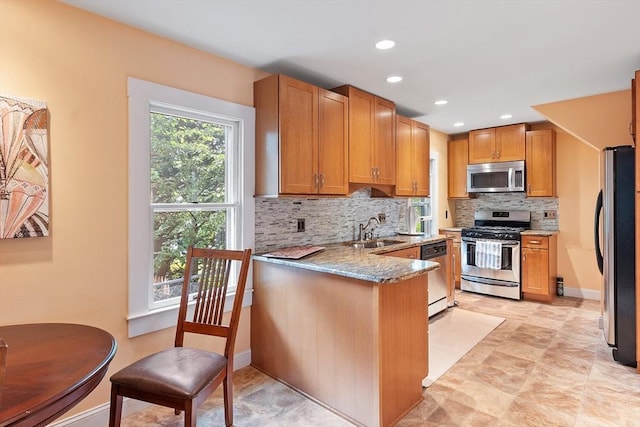 20 Walden St, Lowell, MA 01851 - kitchen featuring stainless steel appliances, a sink, decorative backsplash, light stone countertops, and baseboards