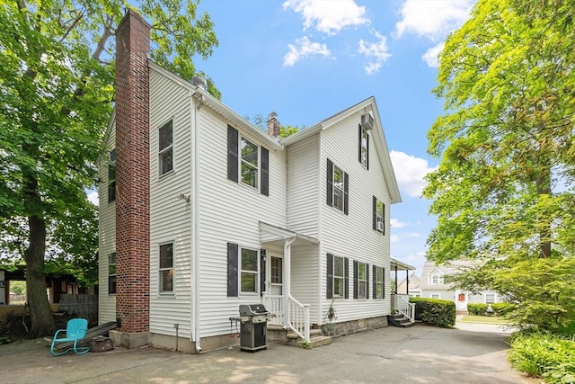 20 Walden St, Lowell, MA 01851 - rear view of house with a chimney and a patio area