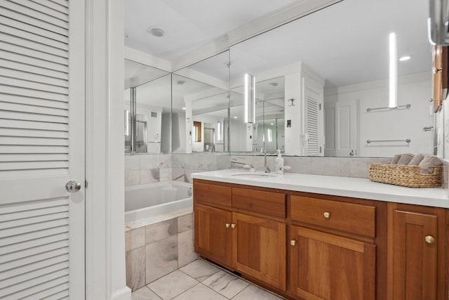 bathroom with tiled bath, ornamental molding, and vanity