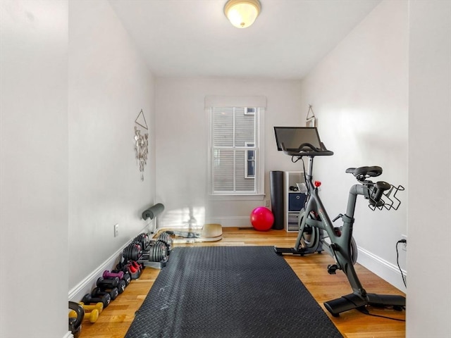 workout area featuring baseboards and wood finished floors