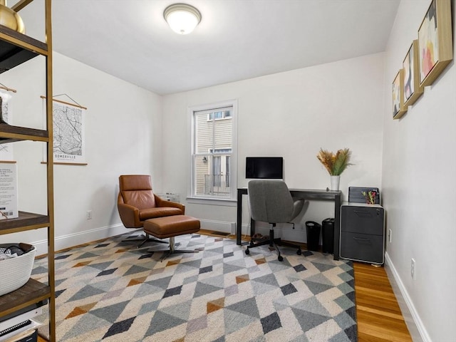 office space with baseboards and wood finished floors