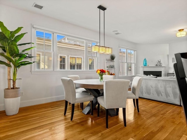 dining area with visible vents, baseboards, and light wood-style floors