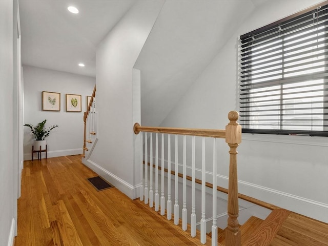 hallway with recessed lighting, wood finished floors, visible vents, and baseboards