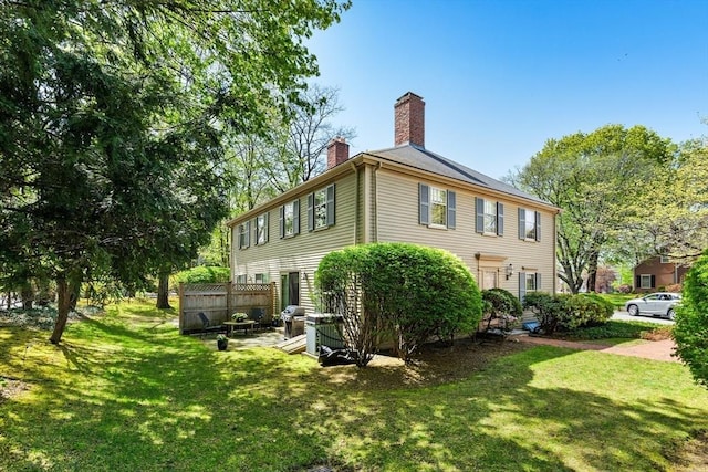 view of home's exterior featuring a lawn and a chimney