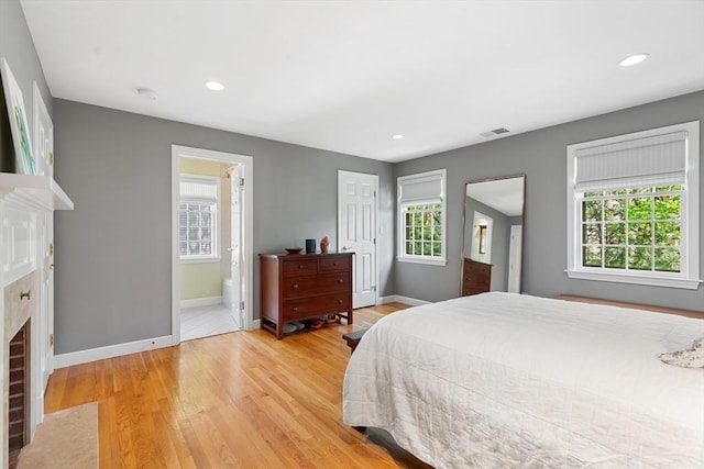 bedroom featuring baseboards, light wood-style flooring, and visible vents