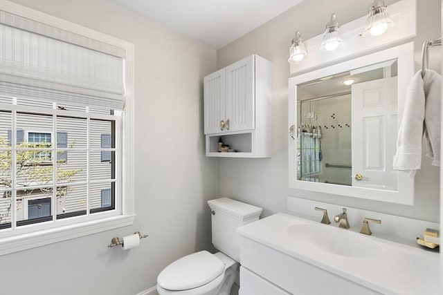 bathroom featuring vanity, baseboards, toilet, and a shower stall