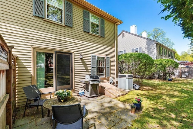back of house featuring a patio, a lawn, and cooling unit