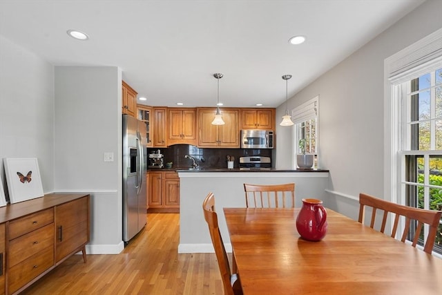 dining area with light wood-type flooring and recessed lighting