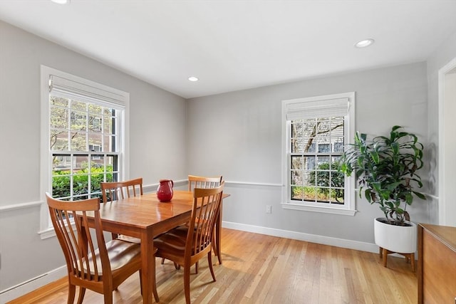 dining area with baseboards, a wealth of natural light, and light wood-style floors