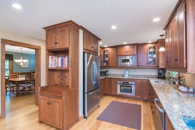 137 French King Hwy, Gill, MA 01354 - kitchen with stainless steel appliances, light wood finished floors, light stone countertops, glass insert cabinets, and a sink