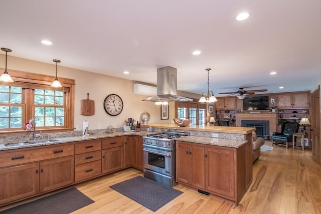 137 French King Hwy, Gill, MA 01354 - kitchen featuring high end stove, island range hood, a sink, a peninsula, and a ceiling fan