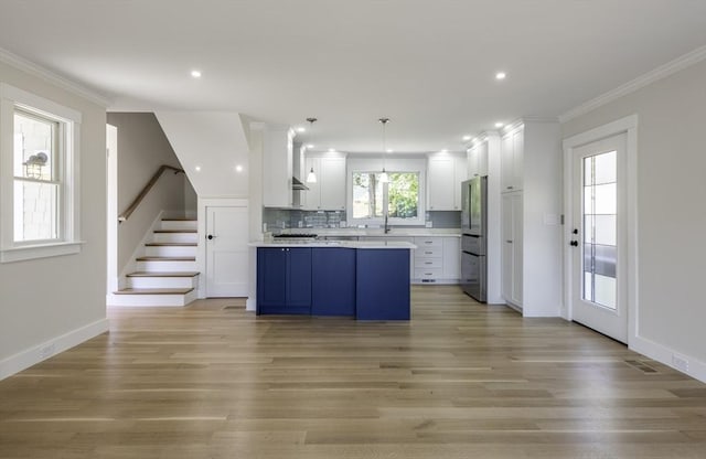 7 Cove Way, Gloucester, MA 01930 - kitchen with freestanding refrigerator, light countertops, a sink, light wood-style floors, and ornamental molding