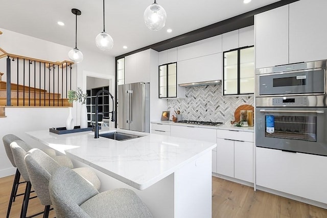 kitchen featuring stainless steel appliances, tasteful backsplash, modern cabinets, white cabinetry, and recessed lighting