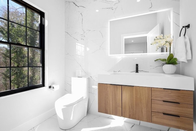 bathroom with marble tiled flooring, vanity, and toilet