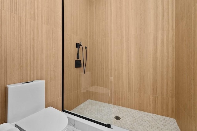 full bathroom with a tile shower and toilet