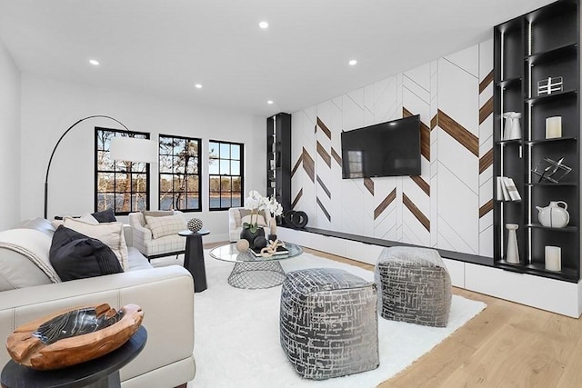 living area with recessed lighting, wood finished floors, and an accent wall