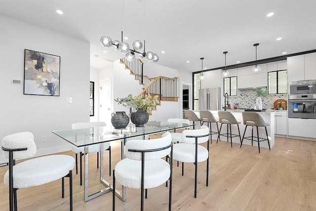 dining room with recessed lighting, light wood-style floors, and stairway
