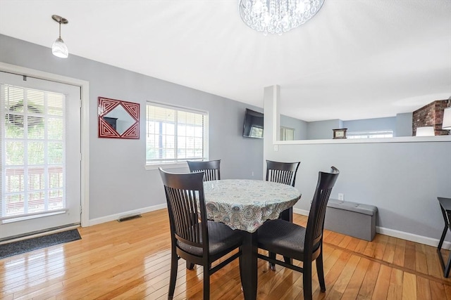 dining space with baseboards, a healthy amount of sunlight, visible vents, and light wood-type flooring