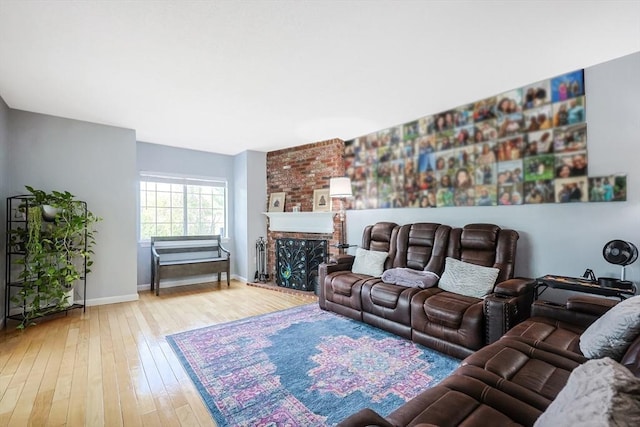 living area featuring wood-type flooring, baseboards, and a fireplace