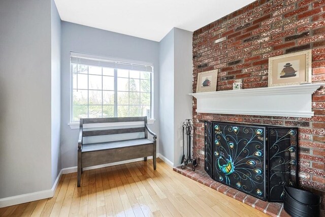 sitting room featuring a fireplace, hardwood / wood-style floors, and baseboards