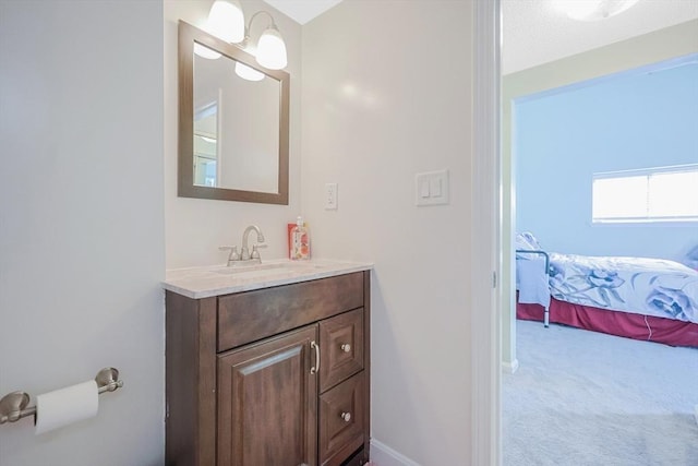 ensuite bathroom featuring baseboards, vanity, and connected bathroom