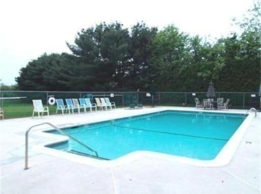 community pool featuring fence and a patio area