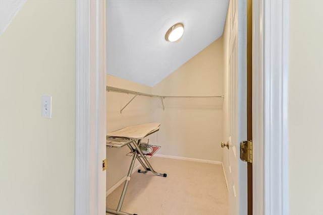 walk in closet featuring carpet floors and vaulted ceiling