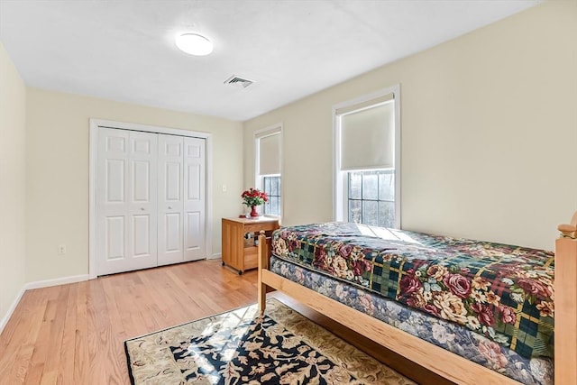 bedroom with light hardwood / wood-style floors and a closet