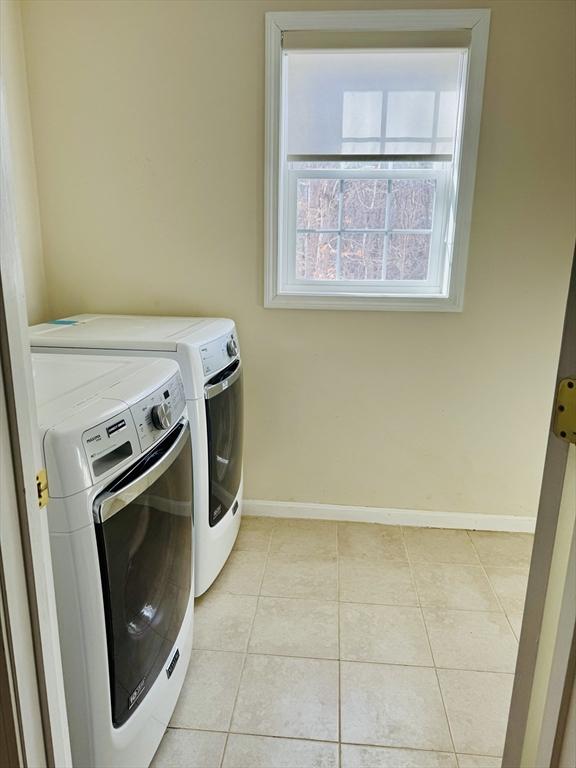 washroom with independent washer and dryer and light tile patterned floors