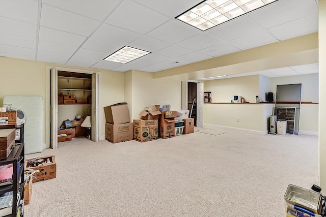 basement with a paneled ceiling and carpet