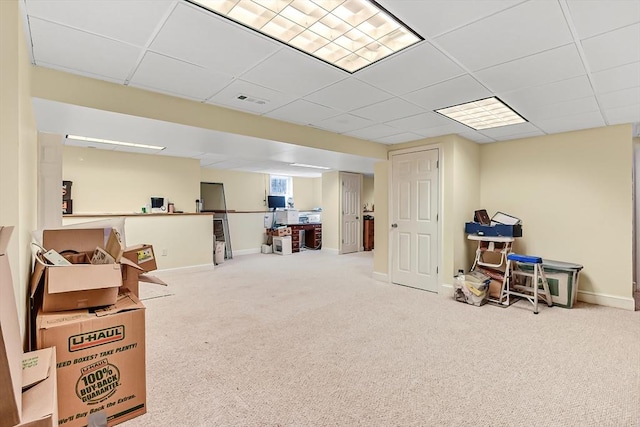 basement with a paneled ceiling and carpet flooring